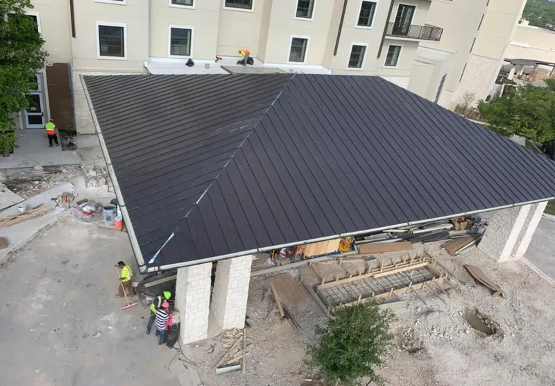 Metal roofing installation team working on a commercial building in Uxbridge